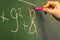 Female Hand Teacher Writing on Green Chalkboard Professor University White Chalk College Education Lesson Math Number Wrong