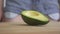 Female hand threwing off sweet sugar cupcake from the wooden board, and instead putting a fresh avocado. Close up.