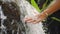 Female Hand Touching Fresh Clean Natural Spring Waterfall in Jungle Rainforest. 4K Slowmotion. Bali, Indonesia.