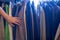 Female hand touching male jackets on rack