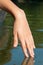 Female hand touching water surface