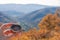 Female hand of traveler, hiker with compass on background autumn forest landscape with mountains on the horizon in