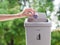 female hand trowing a paper into a garbage bin on bokeh background. cleaning concept.