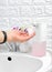 Female hand using Automatic soap dispenser in bathroom