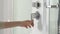 Female hand using bathroom tap in shower cabin. Closeup of a shower knob regulator and his water dispenser. Bathroom tap