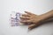 Female hand want to touch a thousand hryvnia. Ukrainian currency with woman`s hand against background. One thousand hryvnia with