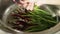 Female hand wash in the sink wild garlic. Clean the cherries in the washing process. Close-up