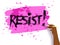 Female hand writing Resist slogan