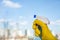 Female hand in yellow gloves cleaning window with spray detergent. Spring cleanup