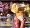 In a female hand, yellow ice cream on a background of a counter with ice cream. Place for text