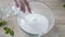 Female hands adding flour, sugar and salt for making dough in bowl, bakery