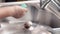 Female hands apply dishwashing liquid to a sponge, slow motion. Kitchen cleaning concept
