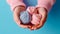 Female hands BEAUTIFUL close-up, knitting for a newborn, crochet.booties, top view on a soft pink blue beige background,tenderness