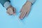 Female hands with beautiful nails and a nail file in their hands on a blue background. Manicure