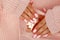 Female hands with beautiful oval-shaped nails, matte pink manicure close-up on a pink knitted sweater background