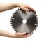 Female hands with black nails manicure with circular saw blade