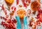 Female hands with blue knitted sweater holding big pumpkin on white blanket with autumn arrangement of red leaves, burning candles