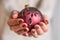 Female hands with brown nail polish manicure holding red Christmas ball