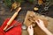 Female hands carve Christmas cookies figures in a deer shape on a kitchen wooden table, top view.