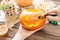 Female hands carving with knife a pumpkin for Halloween.