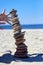 Female hands catch a falling cairn on a sandy beach