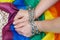 Female hands chained against the background of the LGBT flag. The concept of  the fight for tolerance and equal treatment of