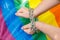 Female hands chained against the background of the LGBT flag. The concept of  the fight for tolerance and equal treatment of
