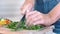 Female hands chopping fresh lush greenery parsley for vegan using professional cooking knife