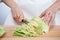 Female hands chopping savoy cabbage