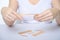 Female hands close-up with a plaster against facial wrinkles. The faceless girl is holding a tape in her hands for a