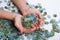 Female hands collect a heap of a broken puzzle on a white background. Organization of the process