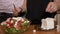 Female hands cook adding cheese to tasty healthy salad prepared in bowl with her friends in kitchen