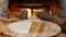 Female hands cooking dough for flapjack on wooden table on fireplace background. Woman cooking traditional turkish