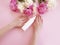 Female hands cream cosmetic flower peony on a colored background