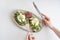 Female hands with cutlery near the plate with toast made with microgreens