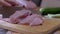 Female Hands Cuts Raw Pork Meat with a Sharp Knife on a Cutting Wood Board. 4K