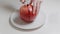 Female hands cutting a ripe juicy pomegranate with a knife