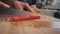 Female hands cutting salmon fillet at kitchen. Closeup hands slicing fresh fish. Woman making salad