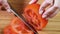 Female hands cutting tomato