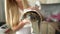 Female hands drying red-eared turtle In white towel after washing In bathtub.