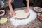 Female Hands Flattening Dough With Lots Of Flour On Marble Table