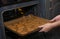 Female hands in flour put christmas cookies in the oven. One of the steps in making gingerbread cookies