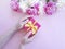 Female hands flower peony gift box decoration on a colored background