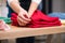 Female hands fold red shirts at clothing store