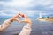 Female hands in the form of heart against the lighthouse