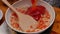 Female hands fries chopped tomatoes and onions making sauce for homemade pizza with healthy ingredients, seasoning with salt and s