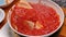 Female hands fries chopped tomatoes and onions making sauce for homemade pizza with healthy ingredients, seasoning with salt and s