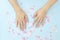 Female hands with a gentle nude manicure on a blue background