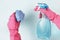 Female hands in glove holds window spray and rag on blue background, top view, spring cleaning concept