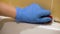 Female hands in gloves removing mold using detergent and brush